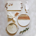 Set of marble and wood cutting boards with kitchen tools on a neutral background