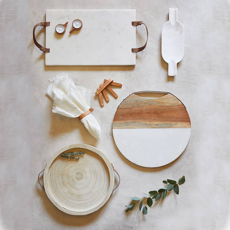 Set of marble and wood cutting boards with kitchen tools on a neutral background