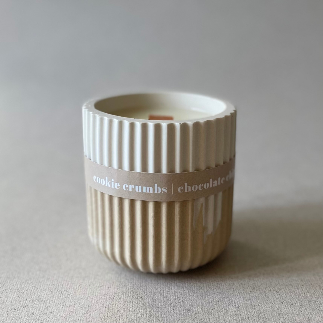 Cylindrical ceramic container with ribbed texture and 'cookie crumbs chocolate' label on a neutral background