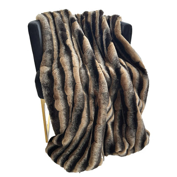 Patterned throw blanket draped over a chair on a white background