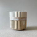 Textured ceramic container with 'cookie crumbs chocolate chip' label on a neutral background