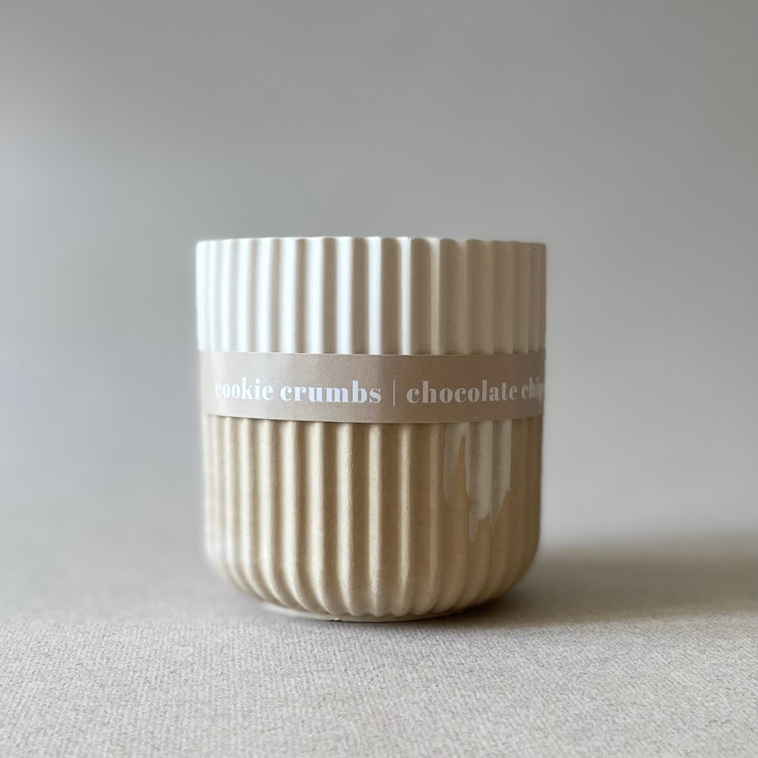 Textured ceramic container with 'cookie crumbs chocolate chip' label on a neutral background