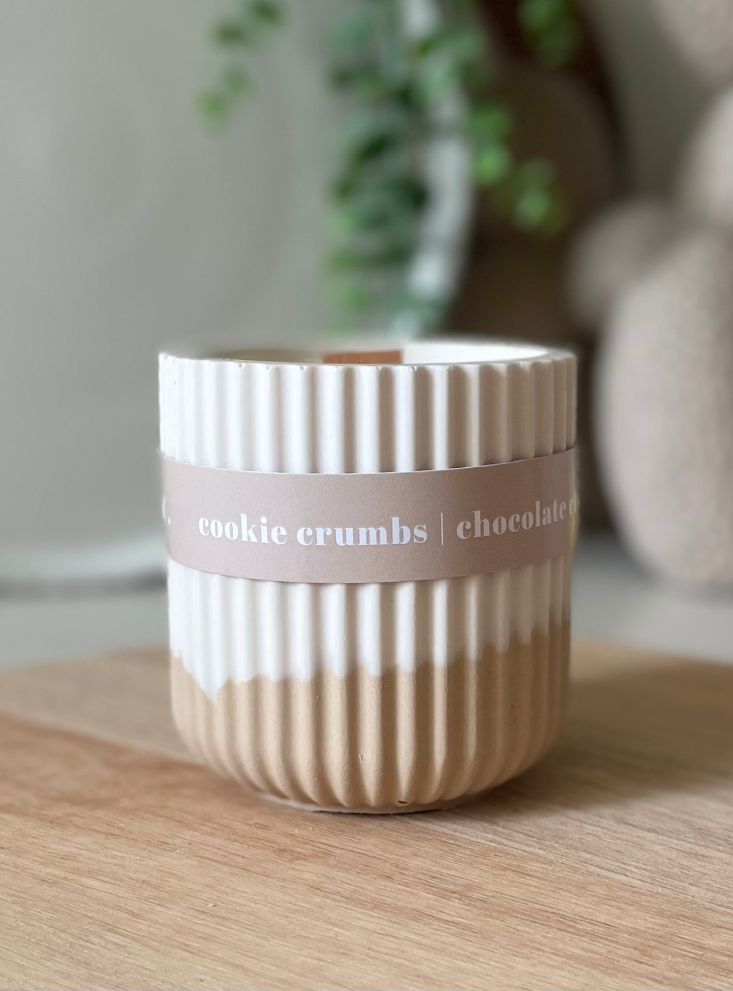 Striped ceramic container with 'cookie crumbs chocolate' label on a wooden surface
