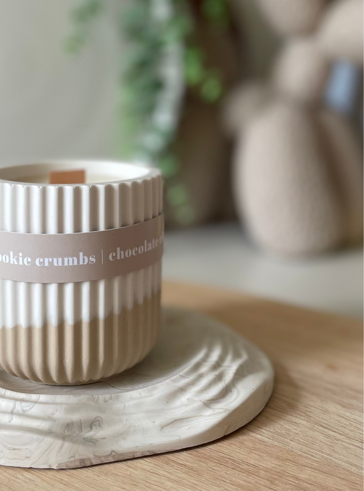 Ceramic cup with text on a wooden coaster on a table with a blurred background
